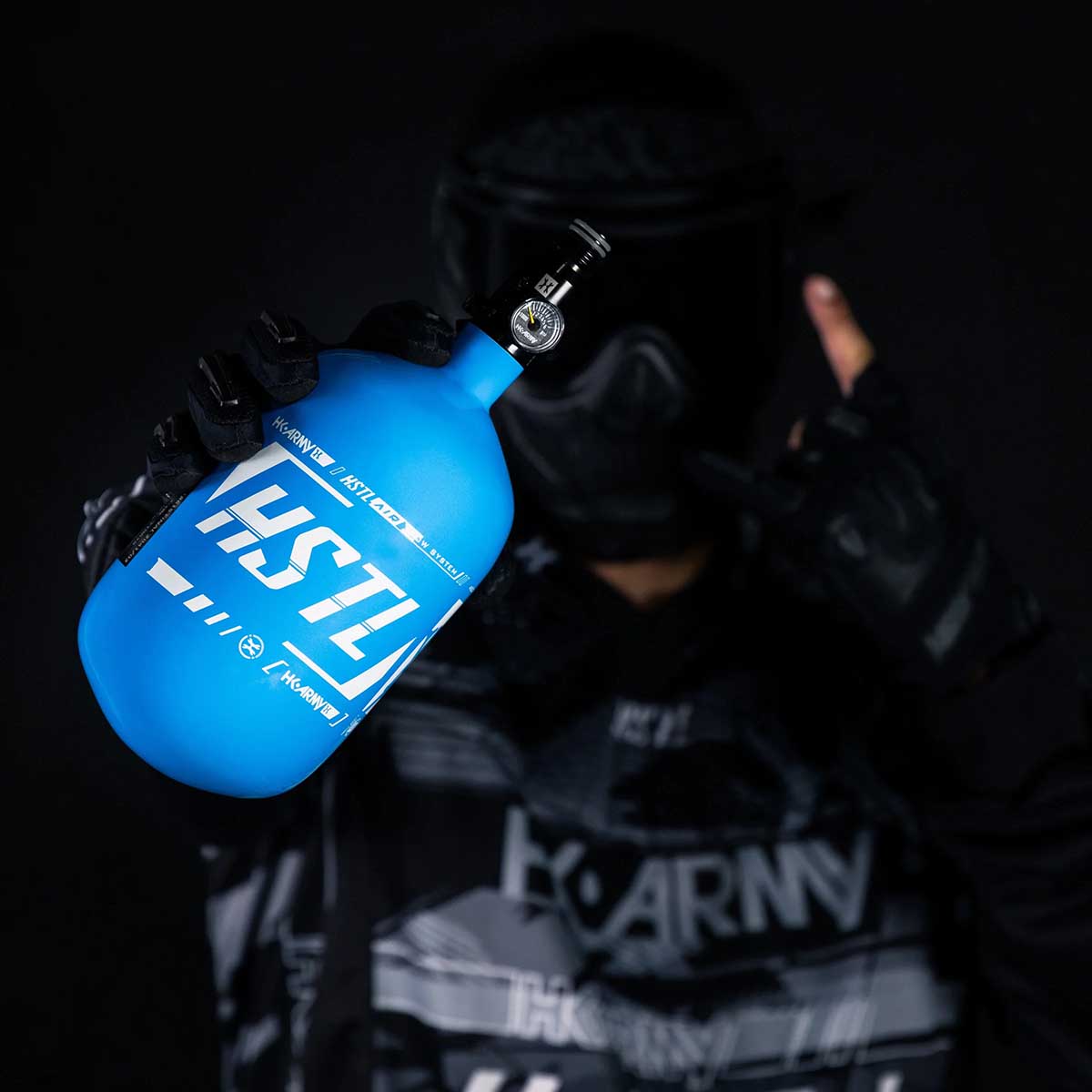 player holding the blue and white HK Army HSTL 68ci 4500psi Carbon Fiber Air Tank