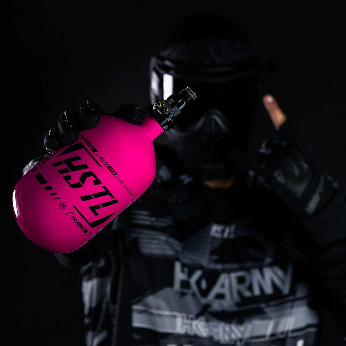 Paintball player holding the pink HK Army HSTL 68ci 4500psi Compressed Air Tank