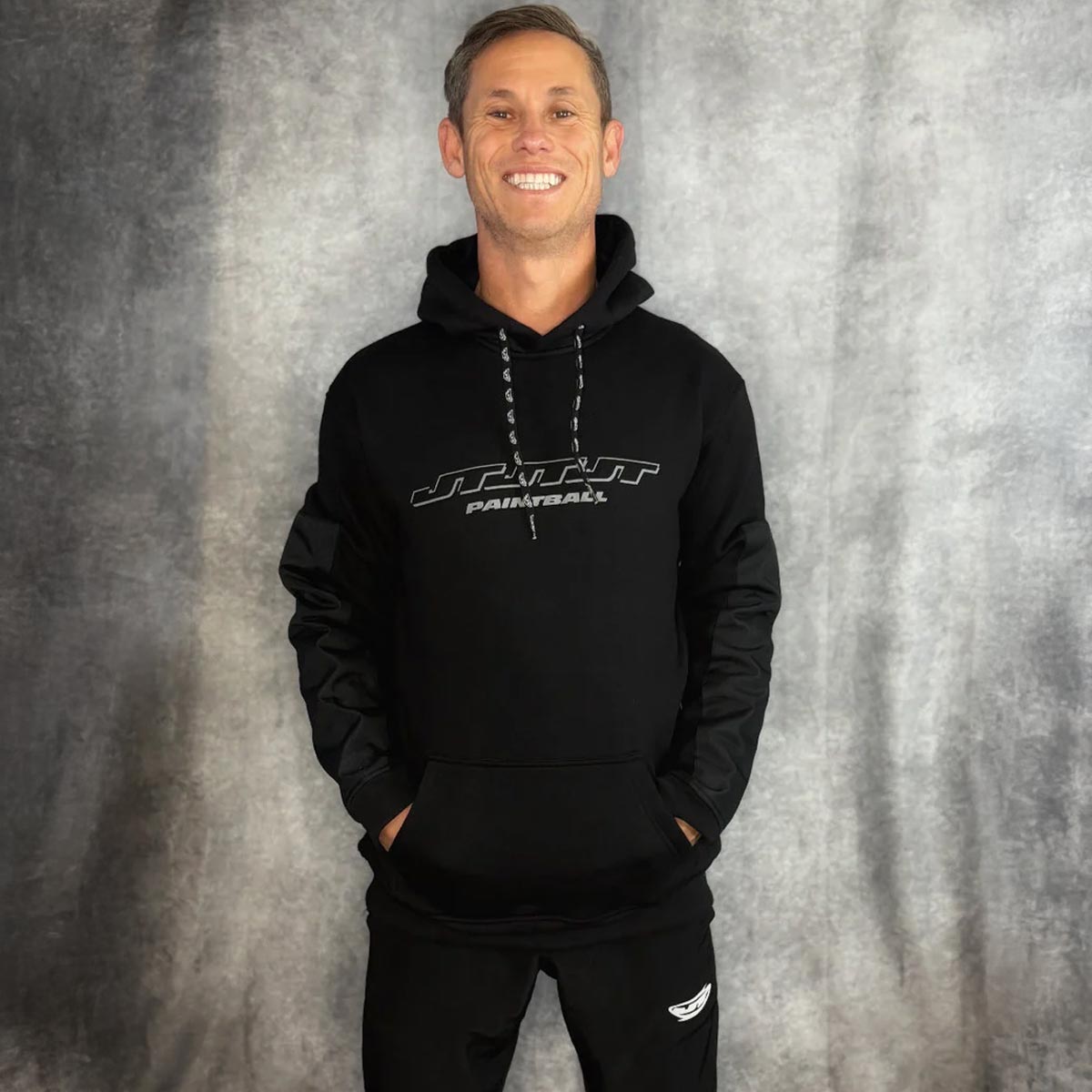 JT Paintball Grind Playing Hoodie Black on a person on a grey background