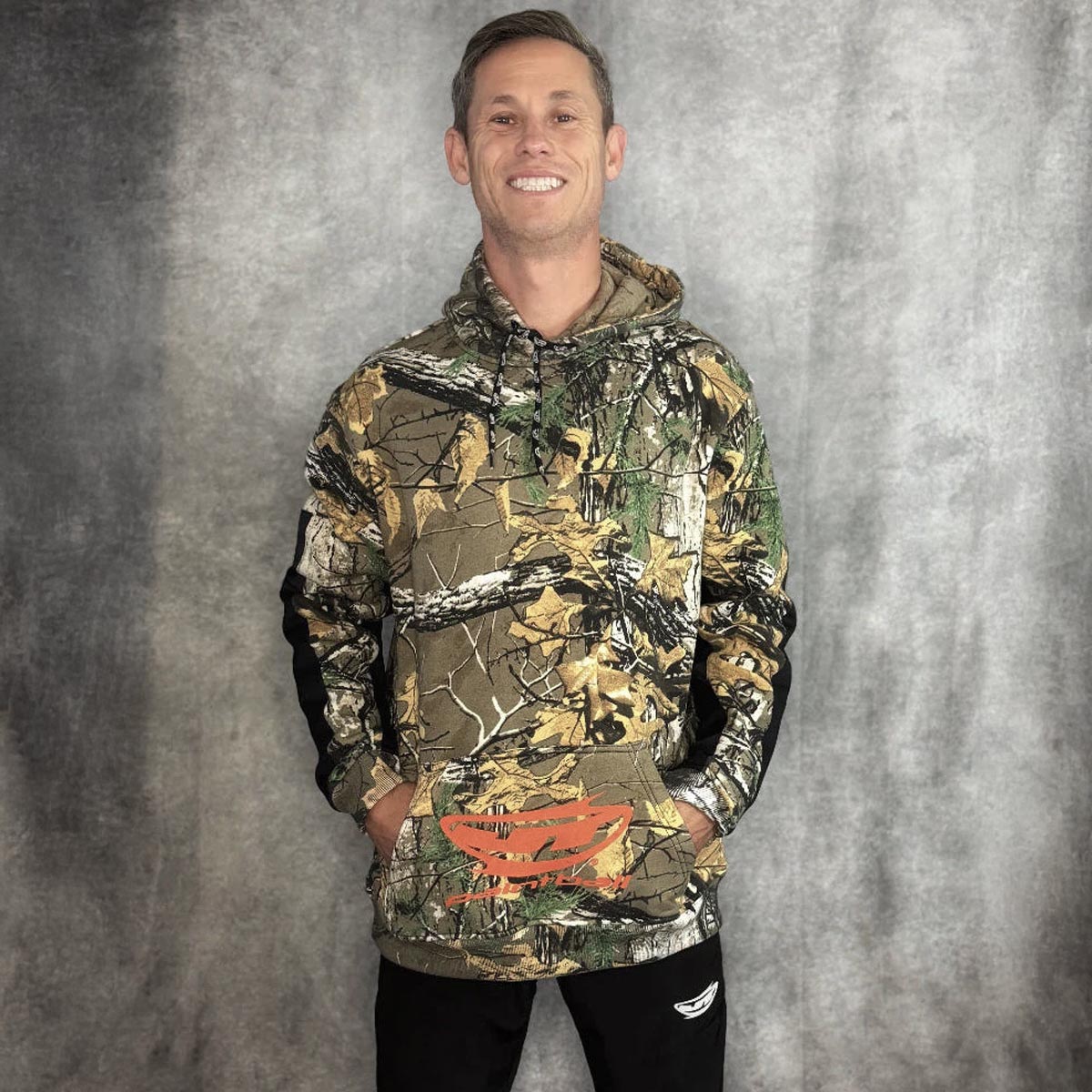 JT Paintball Grind Playing Hoodie Branch Camo on model on a grey background