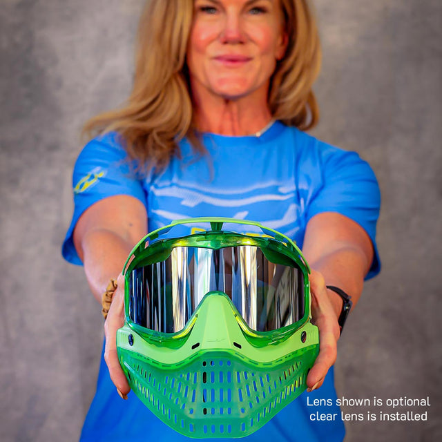 Person holding a green JT ProFlex Birthstone Ice August Peridot
paintball mask with clear lens against a gray background