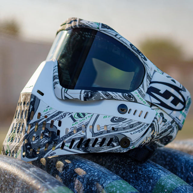 White money pattern JT ProFlex 100 Dollar Bill Goggle LE with Extra Lens in smoke outside on a barrel