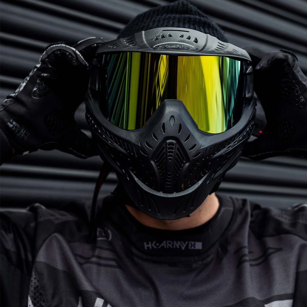 Front of Black HK Army HSTL Thermal Paintball Goggle mask with a gold lens shown on a person.