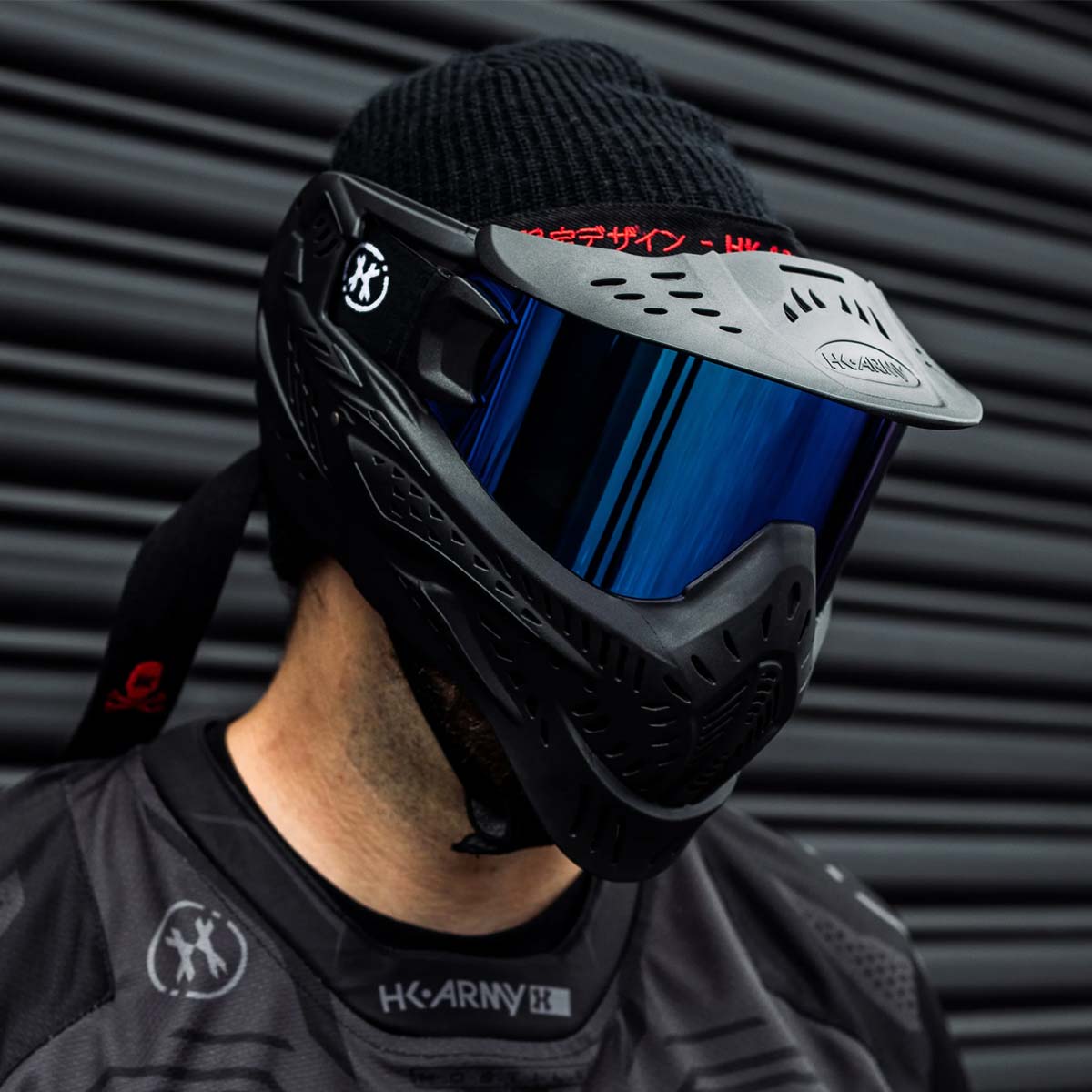 Black HK Army HSTL Thermal Paintball Goggle mask with a blue lens and white AK logo on the side, shown on a person