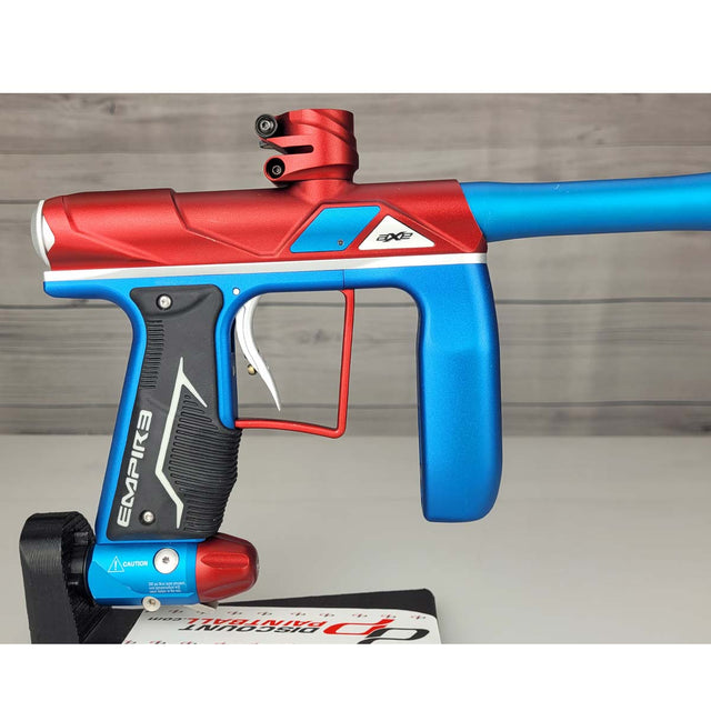 Right side body USED Empire Axe Pro Red Blue Silver paintball marker on a panel background.