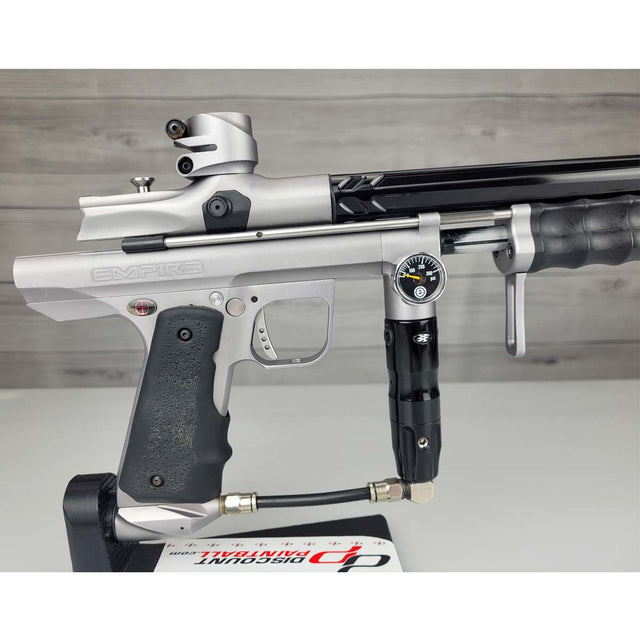 Right side body USED Empire Sniper Pump Grey paintball marker with a black and silver design on a white surface with a wooden background