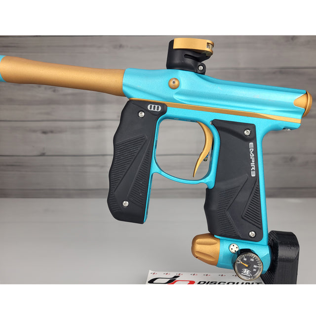 Blue and gold paintball gun on a gray background