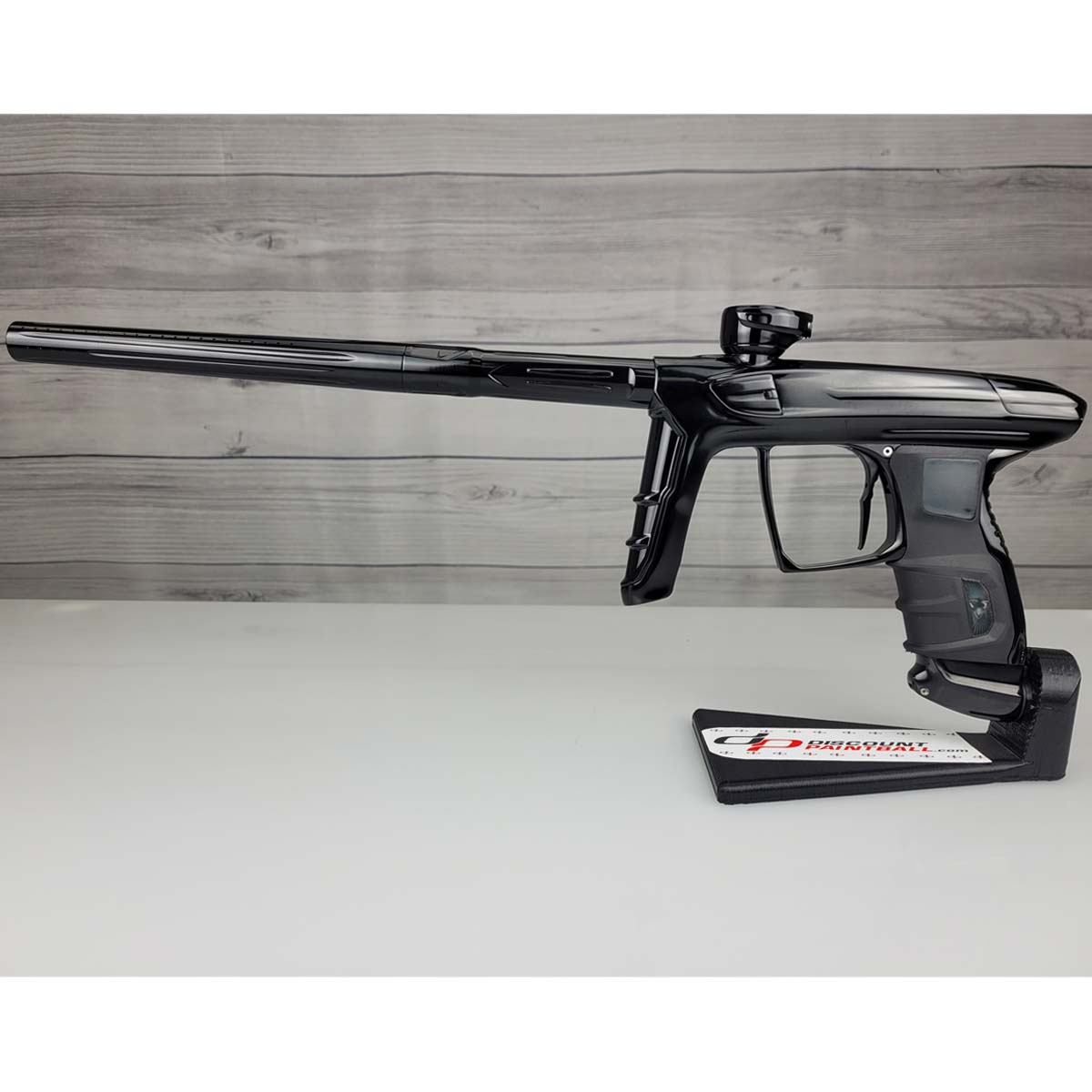 Left side USED DLX Luxe IDOL Paintball Marker Black Polished on a woodgrain background