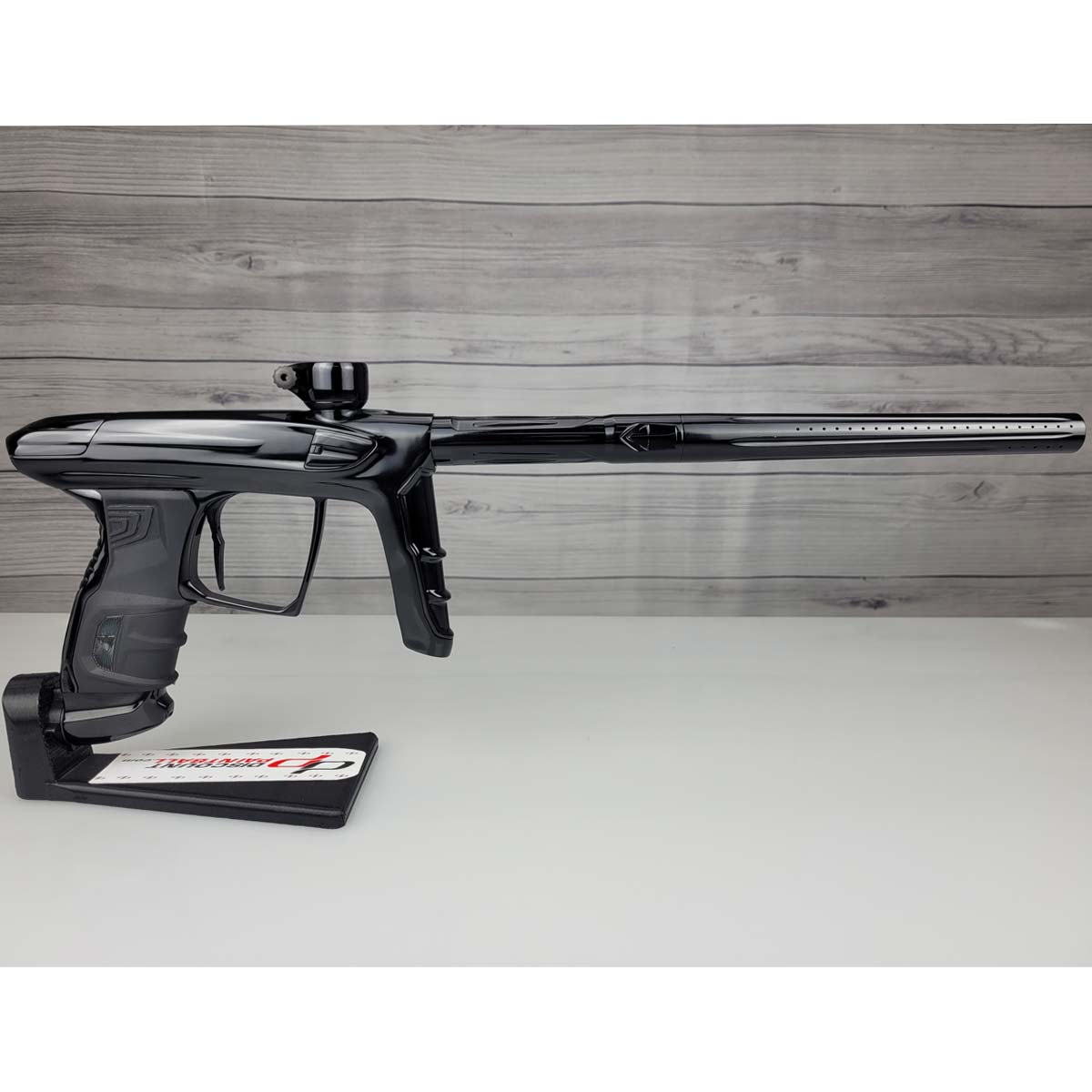 Right side USED DLX Luxe IDOL Paintball Marker Black Polished on a woodgrain background