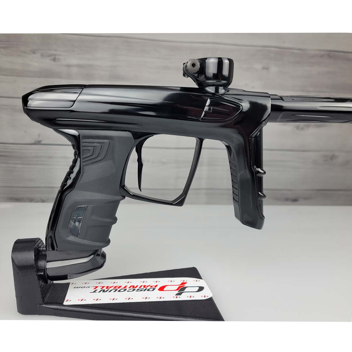 Right side close up USED DLX Luxe IDOL Paintball Marker Black Polished on a woodgrain background