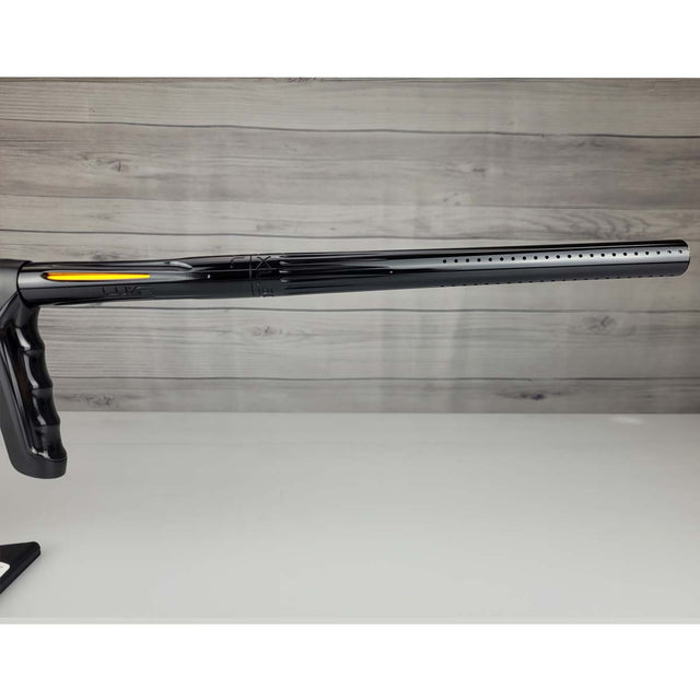 Right side barrel USED DLX Luxe TM40 Paintball Marker Black against a woodgrain background