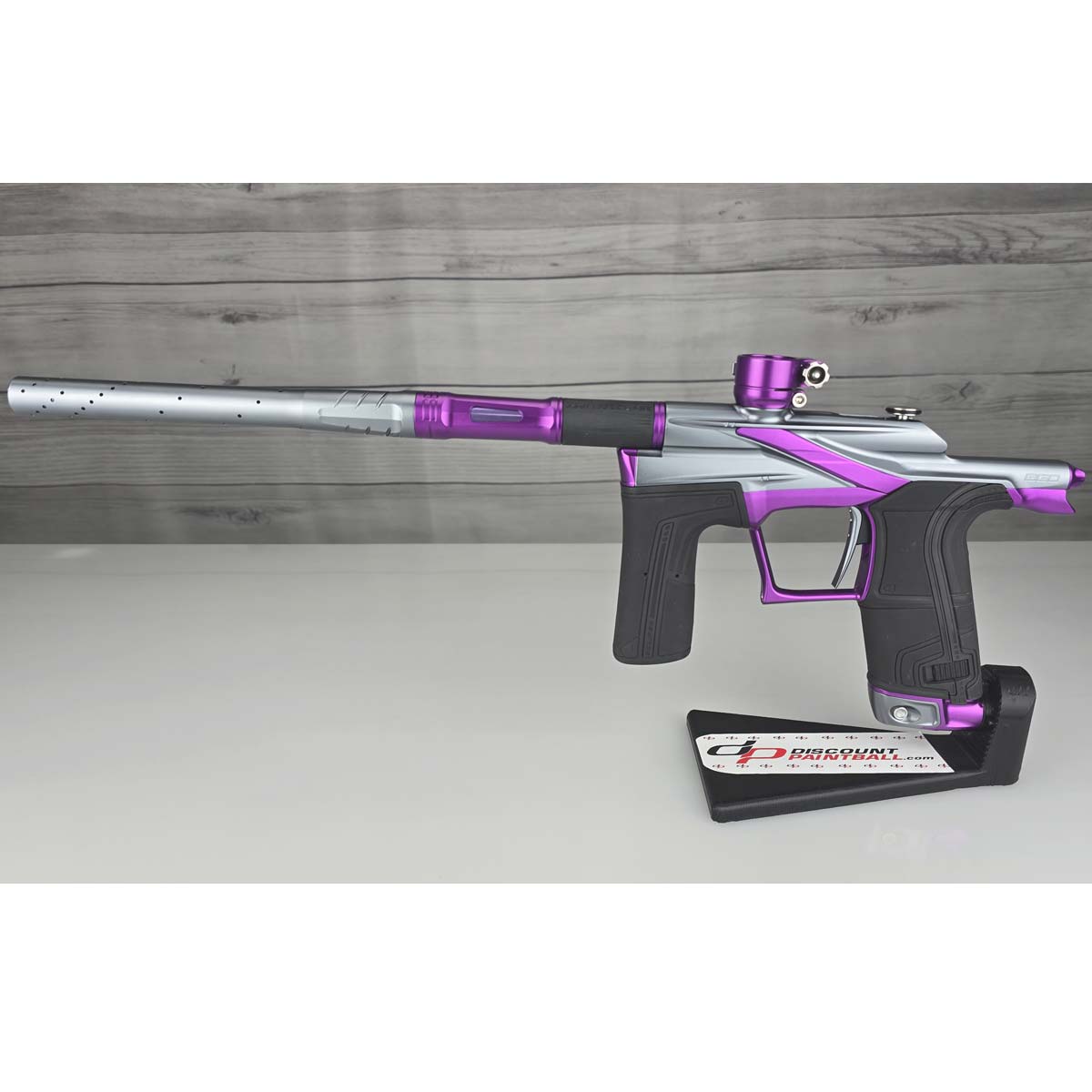 Purple and silver USED Planet Eclipse LV2 Paintball Marker Havoc Grey Purple on a white surface with a wooden background