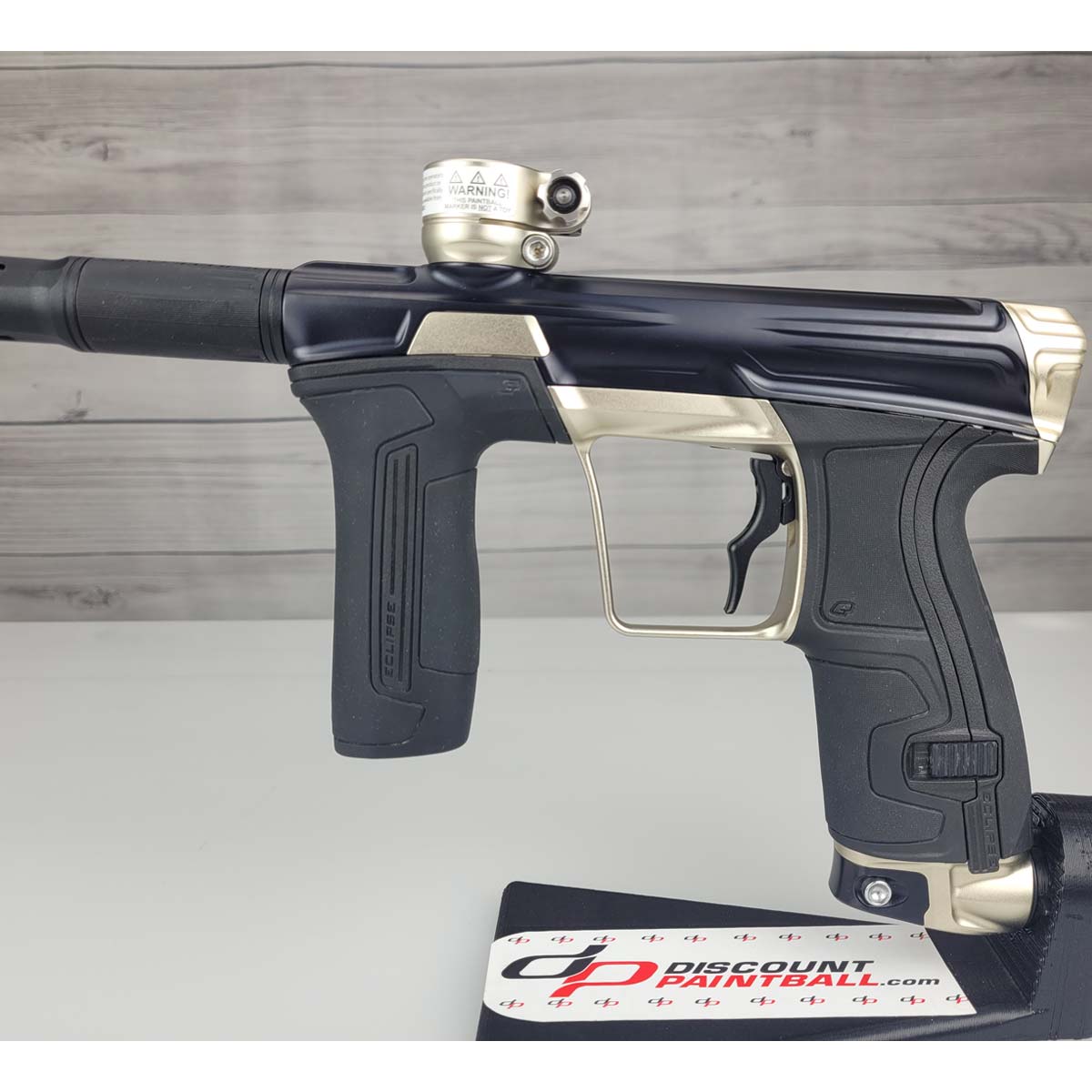 Left side body USED Planet Eclipse CS2 Paintball Marker Black Sandstone on a white surface and wooden background