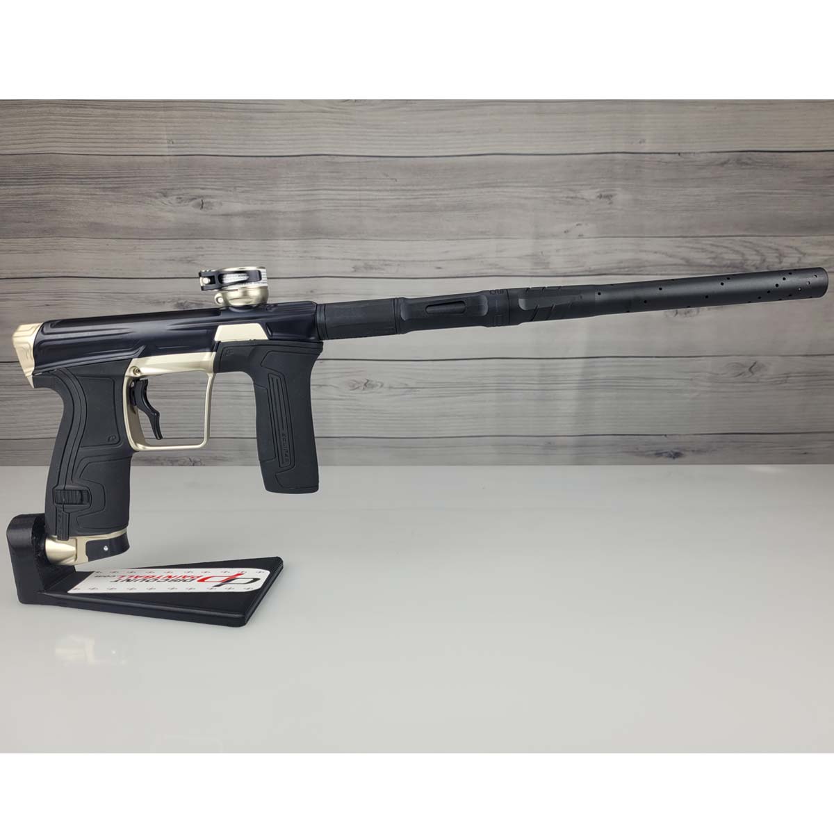 Right side USED Planet Eclipse CS2 Paintball Marker Black Sandstone on a white surface and wooden background