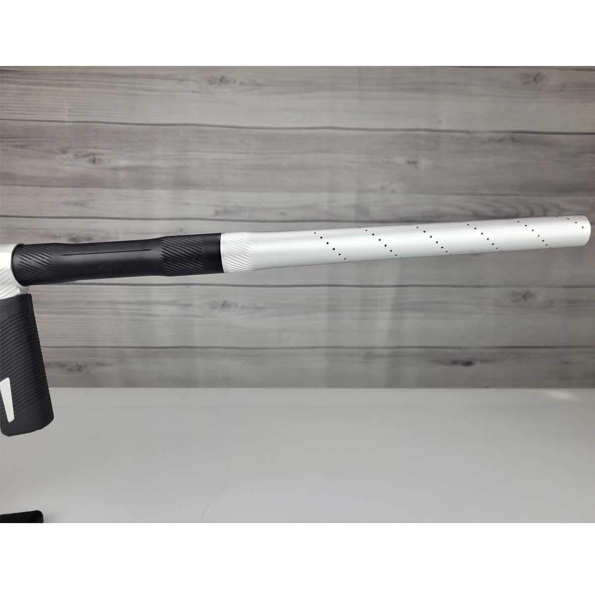 Right side barrel USED Shocker Era Silver black paintball marker in a stand on a woodgrain background.
