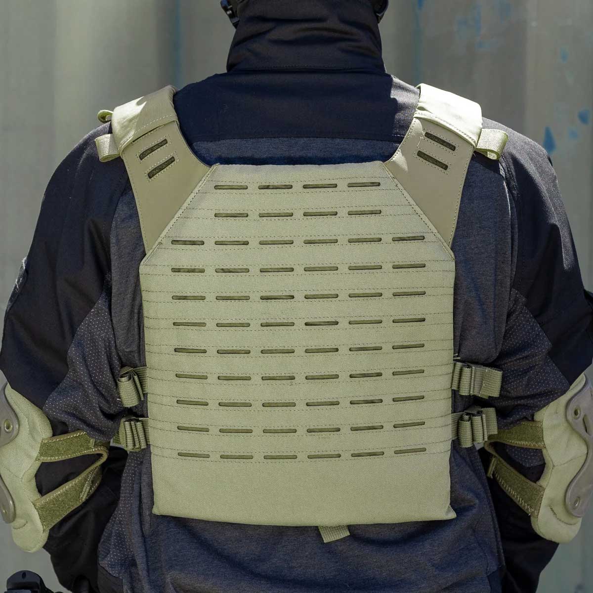 Back of olive green BSX Plate Carrier LC for airsoft and paintball with mags on a person dressed in tactical gear and black gloves