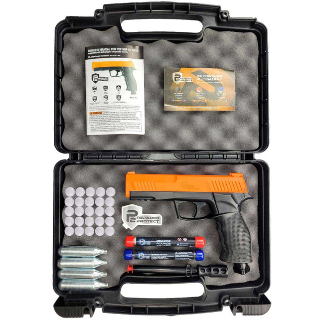 The image shows an open black case holding a .50 caliber Umarex HDP50 Gen 2 P2P Home Defense Pistol with orange accents, accompanied by 12-gram CO2 cartridges, a cleaning rod, a lockable case, and a assortment of round projectiles including pepper rounds.