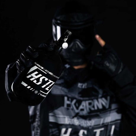 Paintball Player holding the light weight HK Army HSTL 68ci 4500psi Carbon Fiber Air Tank Black White