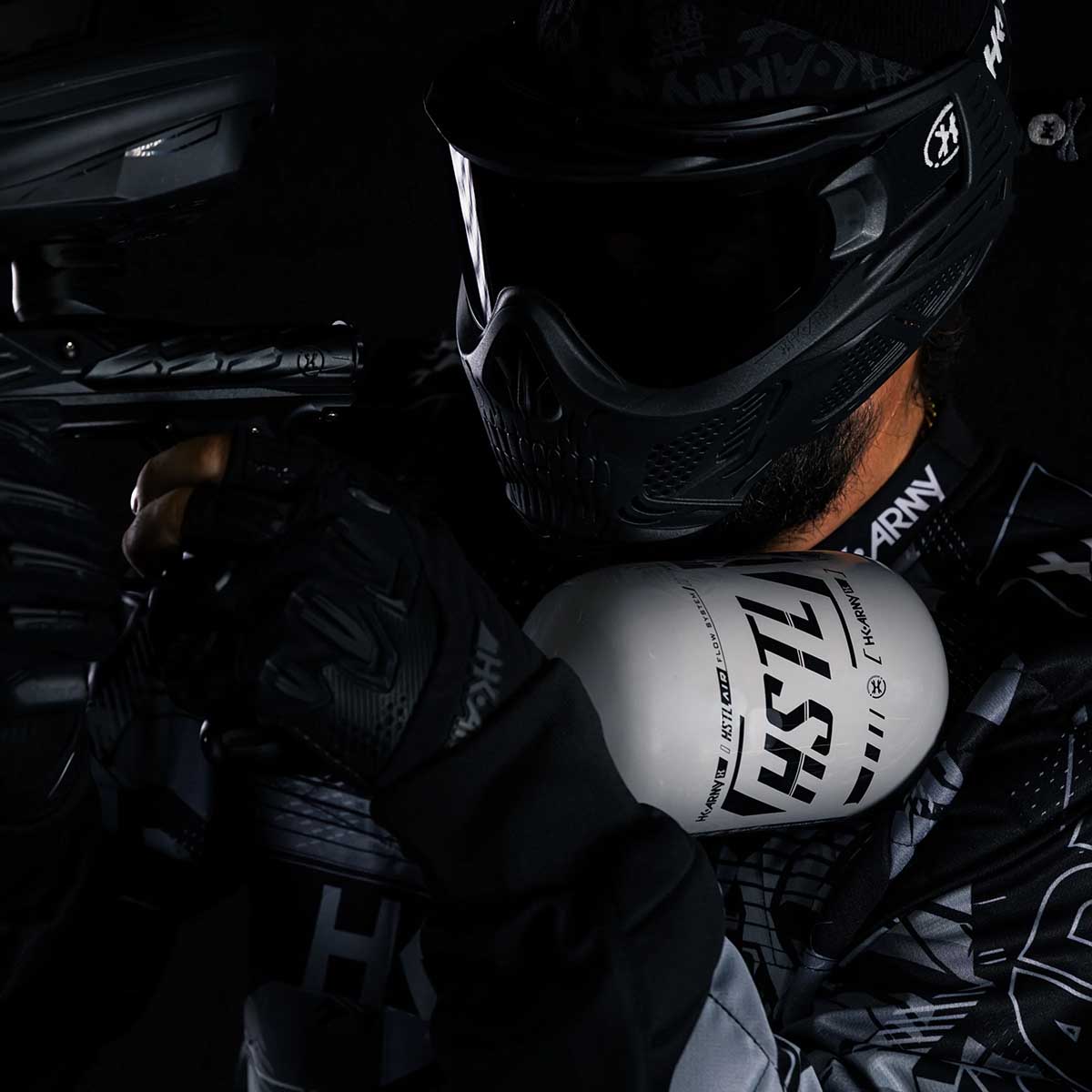 player in HK Army clothing using a grey and black HK Army HSTL 68ci 4500psi Carbon Fiber Air Tank