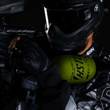 Paintball player holding the Olive HK Army HSTL 68ci 4500psi Compressed Air Tank mounted in marker