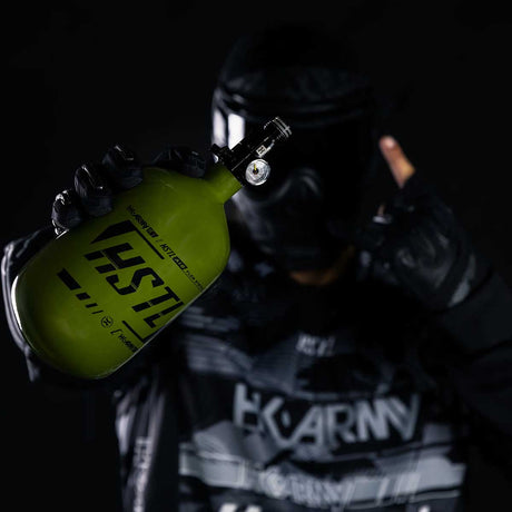 Paintball player holding the Olive HK Army HSTL 68ci 4500psi Compressed Air Tank