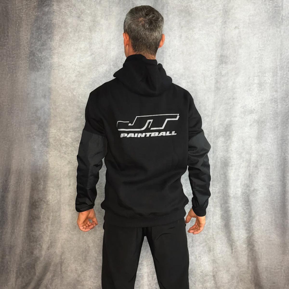JT Paintball Grind Playing Hoodie Black on a person on a grey background