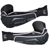 A pair of Exalt T3 Elbow Pads in black color, featuring tri-layer padding technology, moisture-wicking breathable liner, and anti-slip silicone weave on the bicep and thumb cuffs.