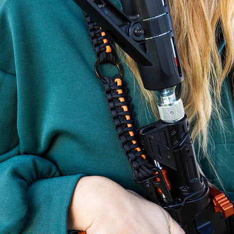 Person holding a launcher with a Byrna sling mount installed