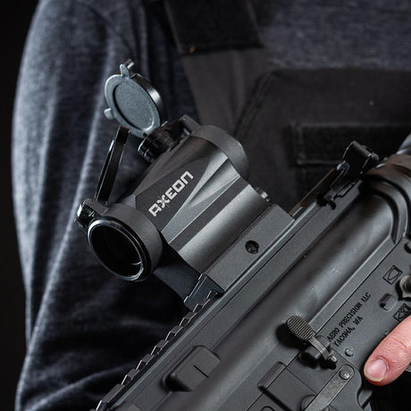 Left side view black AXEON 7XRGB20 Optic Tri Color Dot Sight mounted on a rifle.