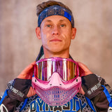 Person holding a pink JT Paintball mask with a blurred background