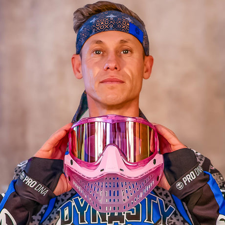 Person holding a pink JT Paintball mask with a blurred background