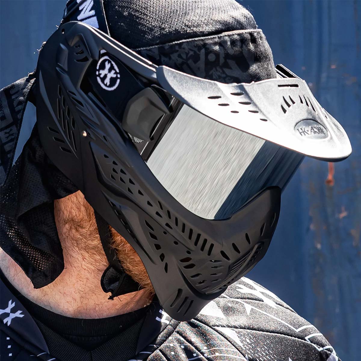 Black HK Army HSTL Thermal Paintball Goggle mask with a silver chrome lens and white AK logo on the side, shown on a person.