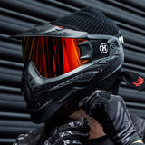 Black HK Army HSTL Thermal Paintball Goggle mask with a fire red lens and white AH logo on the side on a person.