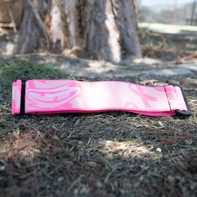 Pink and black camouflage-patterned JT goggle strap on grass
