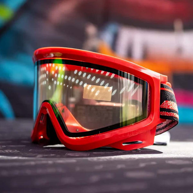 Left side JT QLS Goggle Frame w Lens and Strap Brimstone Red for JT Proflex paintball goggle on a busy background
