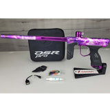 USED DYE DSR Pro PGA Grimace Purple Splash with case, tools, o rings, lube and cable against a wood panel background.