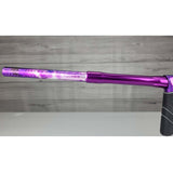 Left side barrel USED DYE DSR Pro PGA Grimace Purple Splash against a wood panel background.