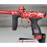 Left side body USED Red and black with white splash pattern Dye M3+ Paintball Marker Red Splash on a woodgrain background.