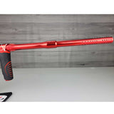 Rights side barrel USED Red and black with white splash pattern Dye M3+ Paintball Marker Red Splash on a woodgrain background.