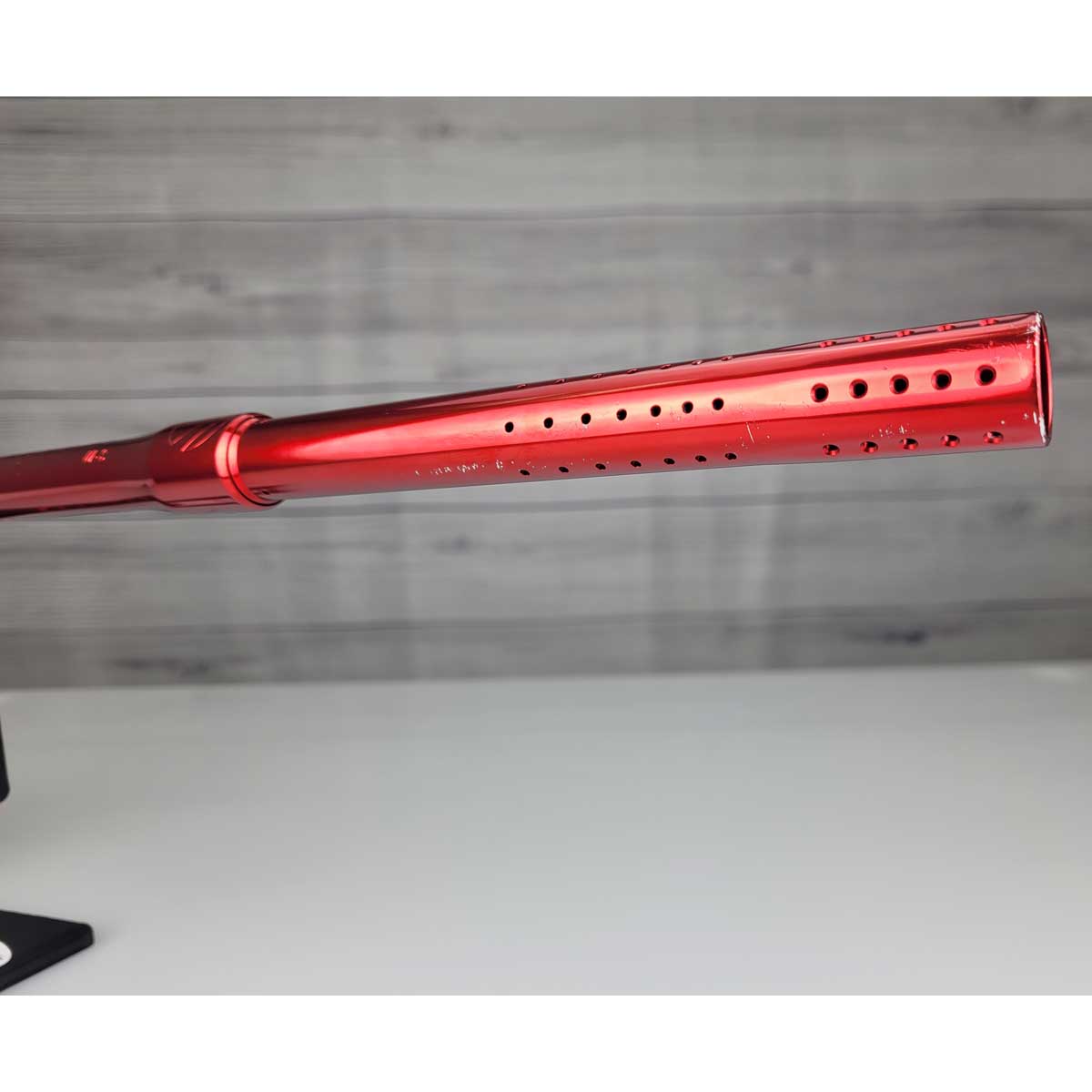 Right side close up of barrel front USED Red and black with white splash pattern Dye M3+ Paintball Marker Red Splash on a woodgrain background.