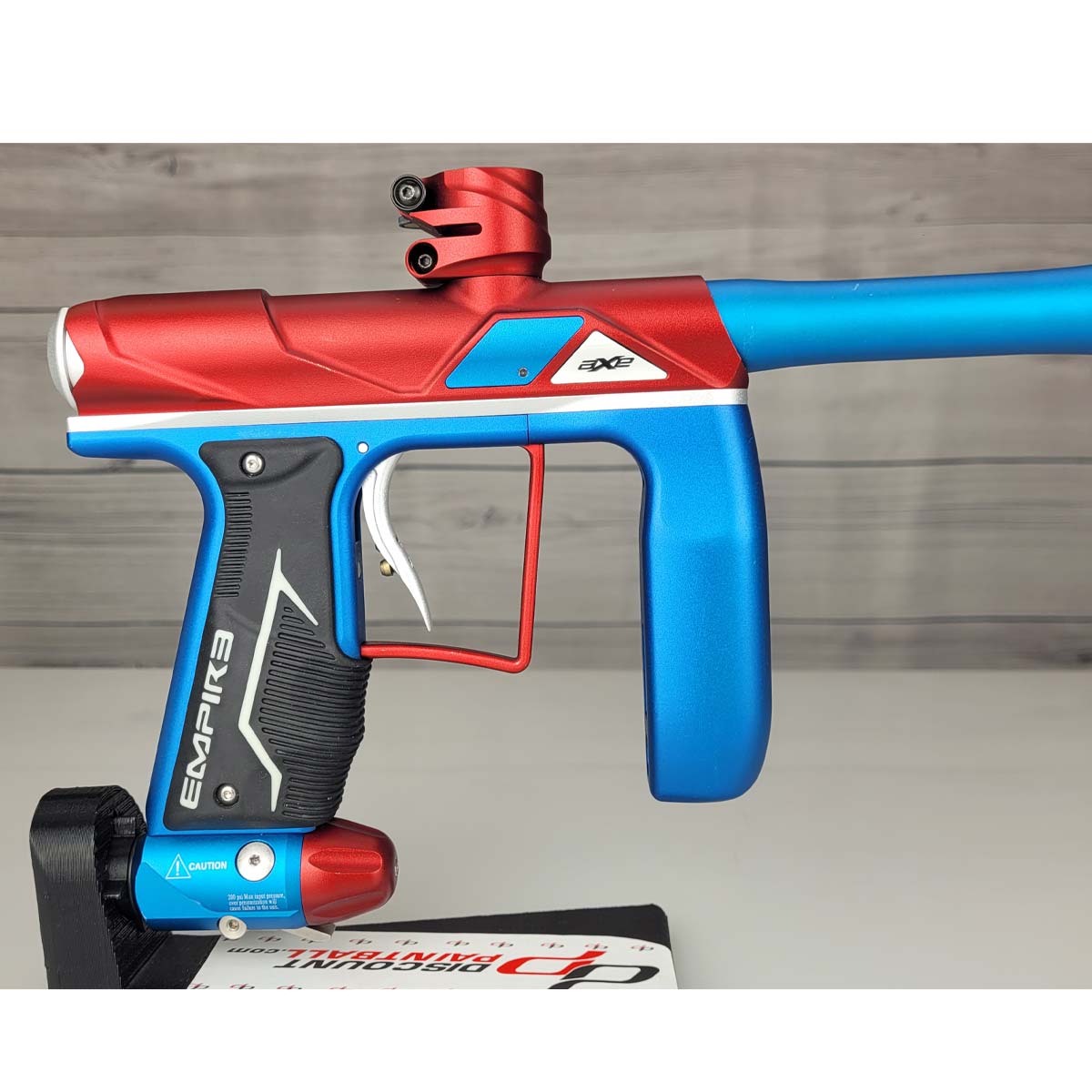 Right side body USED Empire Axe Pro Red Blue Silver paintball marker on a panel background.