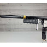 Left side barrel USED Empire Sniper Pump Grey paintball marker with a black and silver design on a white surface with a wooden background