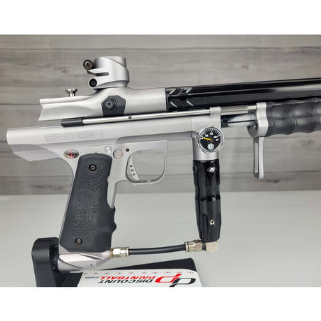 Right side body USED Empire Sniper Pump Grey paintball marker with a black and silver design on a white surface with a wooden background
