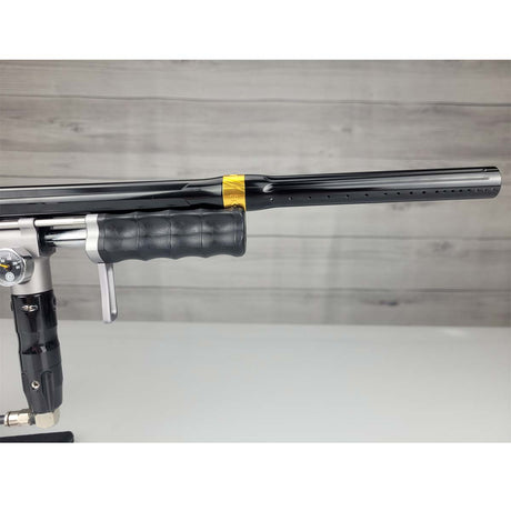 Right side barrel USED Empire Sniper Pump Grey paintball marker with a black and silver design on a white surface with a wooden background