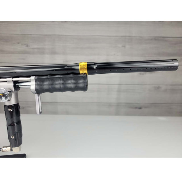 Right side barrel USED Empire Sniper Pump Grey paintball marker with a black and silver design on a white surface with a wooden background