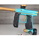 Blue and gold paintball gun on a gray background