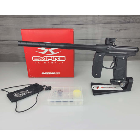 Black USED Empire Mini GS Paintball Marker Black gun with accessories on a gray surface, featuring Empire Paintball branding.
