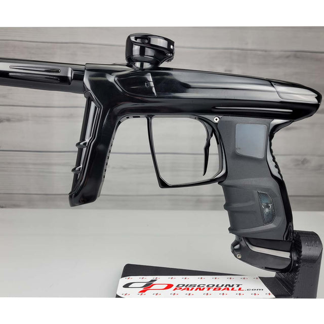 Left side close up USED DLX Luxe IDOL Paintball Marker Black Polished on a woodgrain background