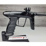 Right side close up USED DLX Luxe IDOL Paintball Marker Black Polished on a woodgrain background