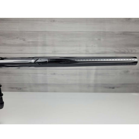 Right side barrel close up USED DLX Luxe IDOL Paintball Marker Black Polished on a woodgrain background